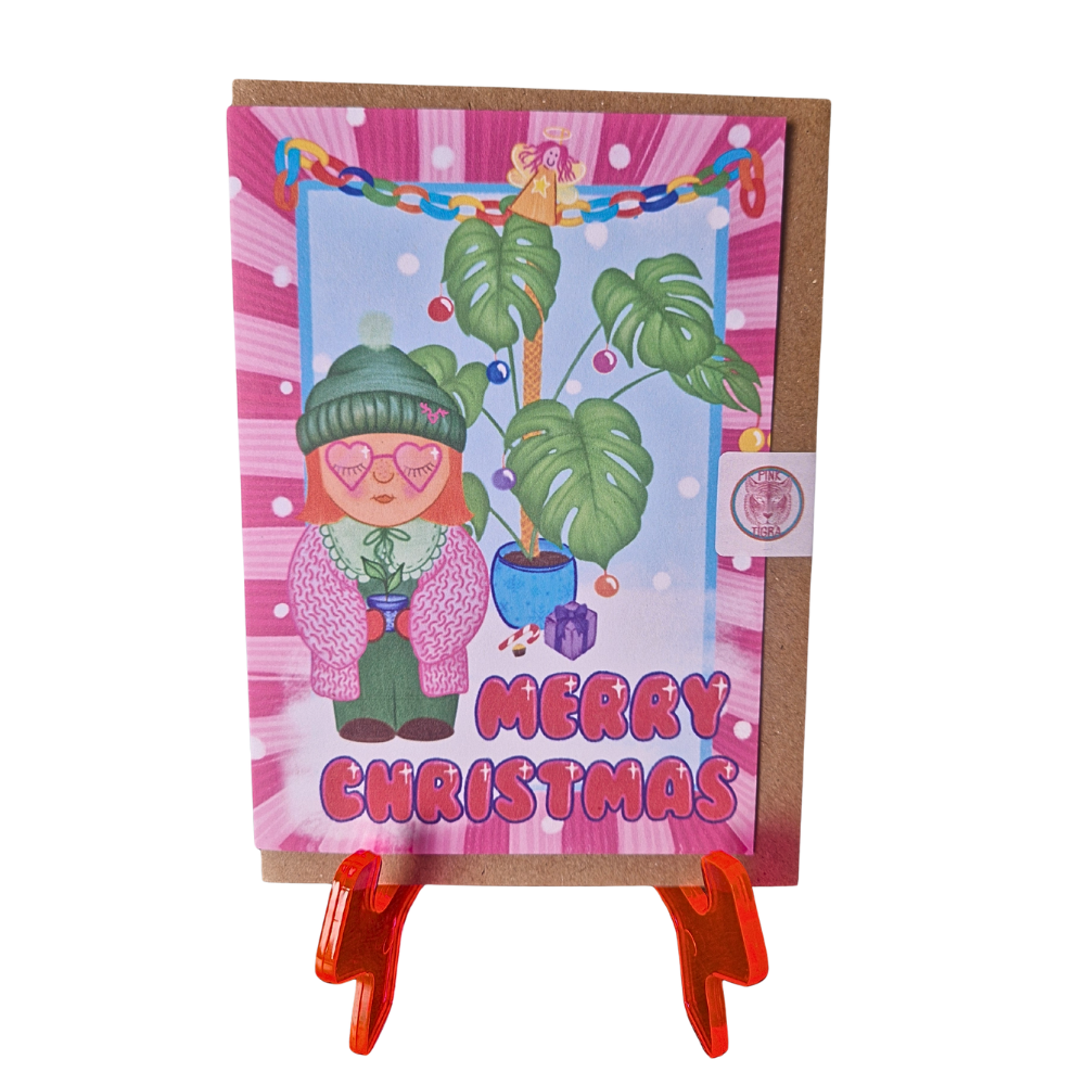 Christmas card with a cartoon character and festive elements on a pink background